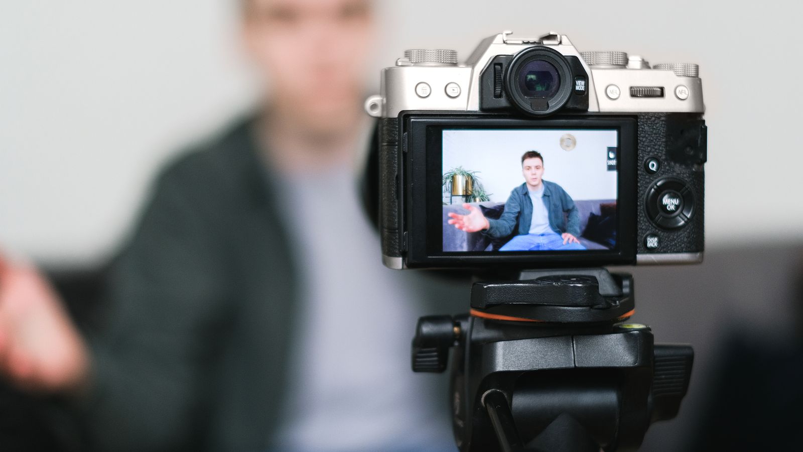 Lifestyle creator filming a handheld vlog in a daylit kitchen
