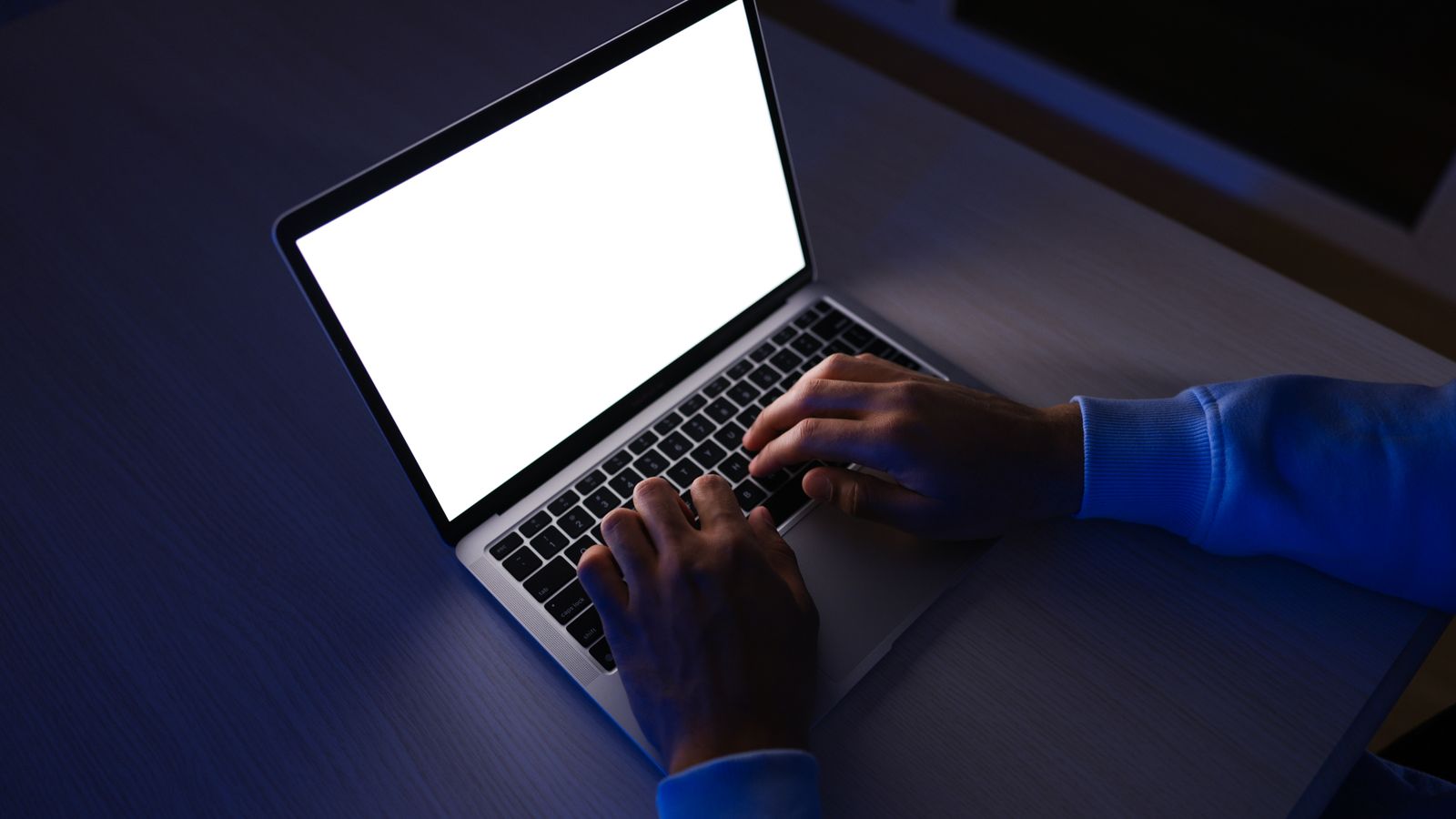 Creator typing a timestamped video prompt on a laptop in a dimly lit room
