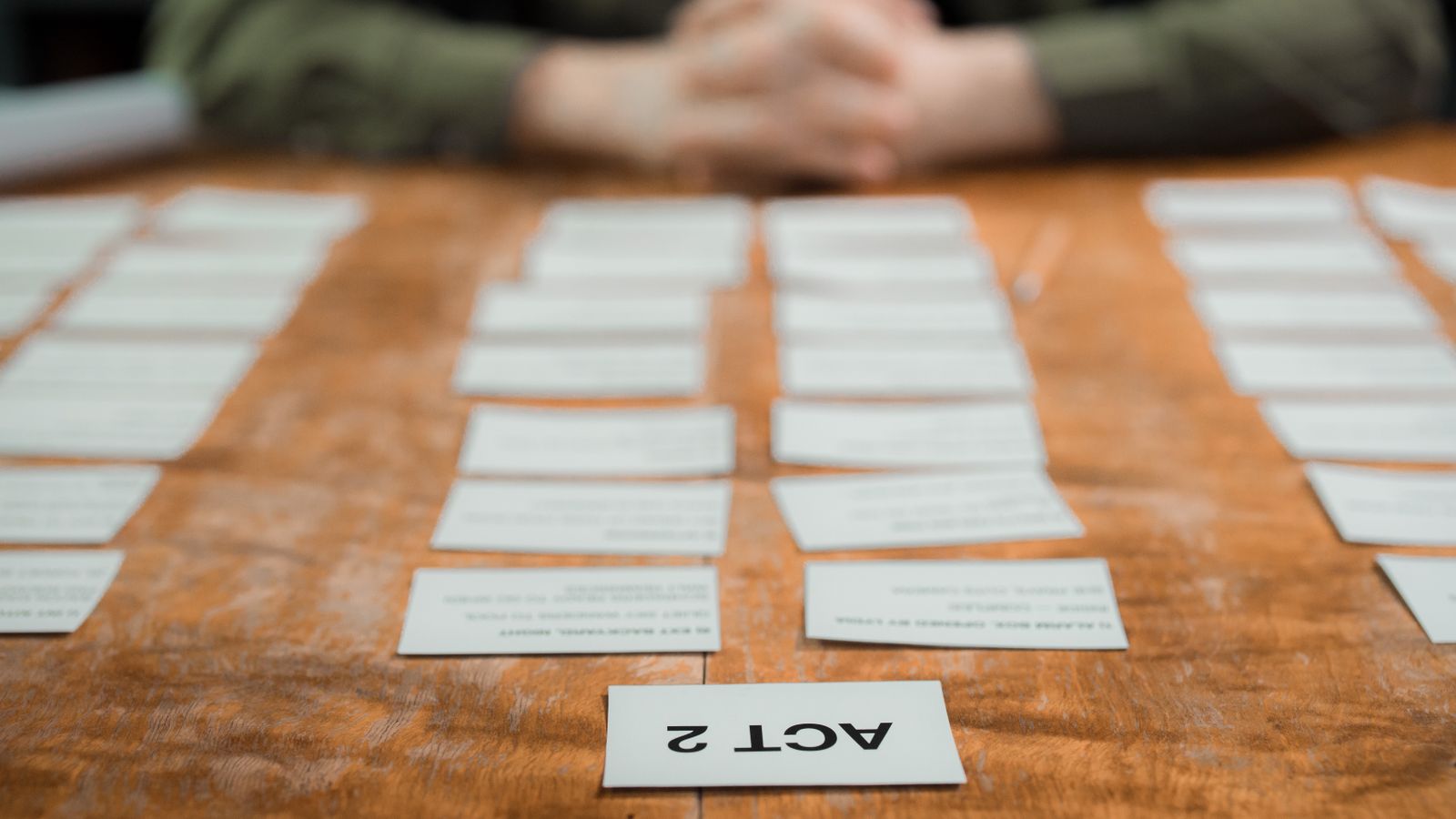 Reference photographs and storyboard frames laid out across a desk for a video shoot